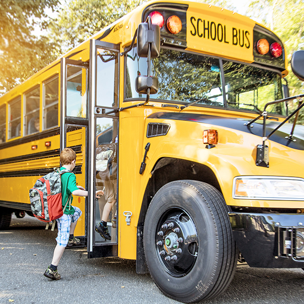 child getting on a yellow school bus