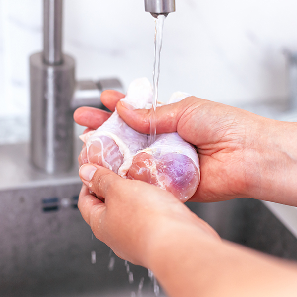 washing chicken under tap