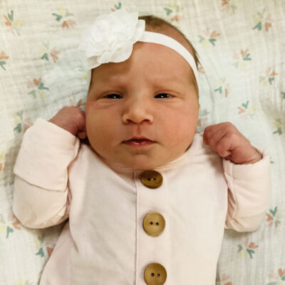 newborn baby in light pink onesie