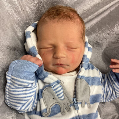 newborn baby in striped elephant onesie
