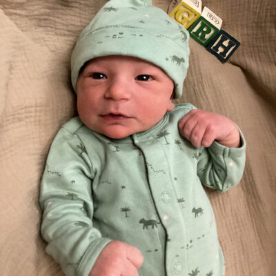 newborn baby in light green onesie