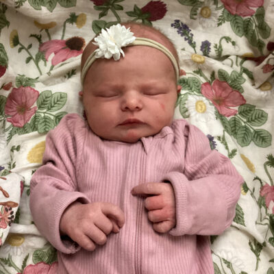 newborn baby in light pink onesie