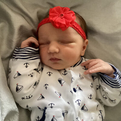 newborn baby in white boat onesie