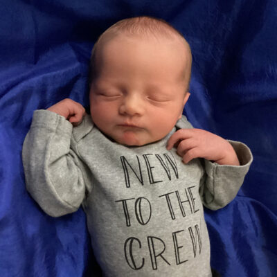 newborn baby in new to the crew onesie