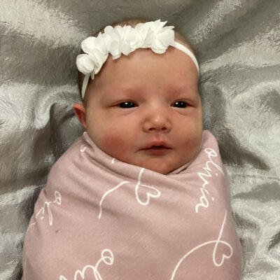 newborn baby in light pink blanket