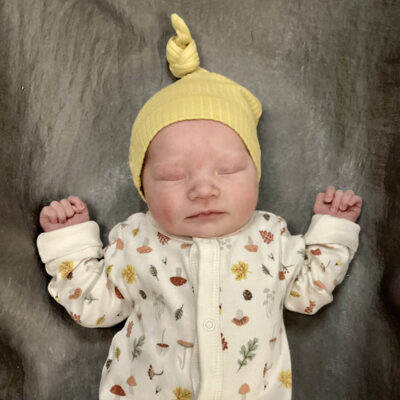 newborn baby in mushroom onesie