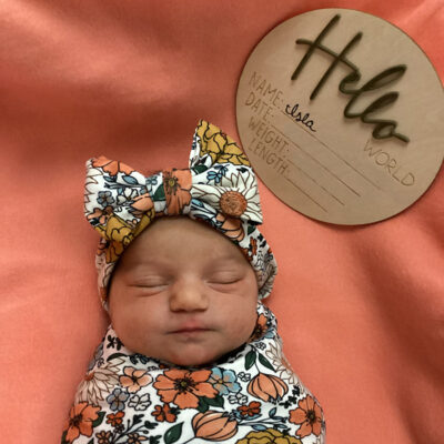 newborn baby in floral onsie