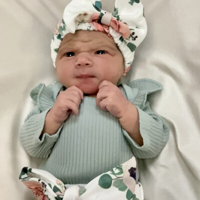 newborn baby in light green floral outfit
