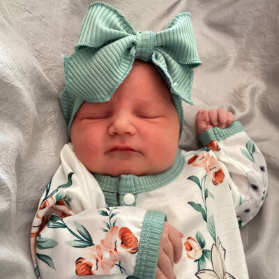 newborn baby with white and green floral onesie