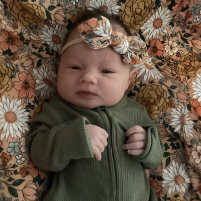 newborn baby in green onesie