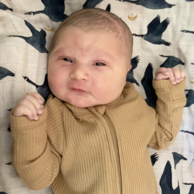 newborn baby in yellow onesie