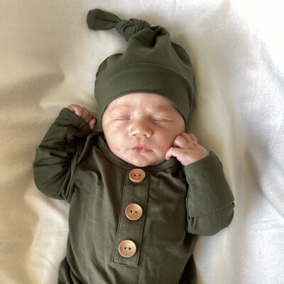 newborn baby in dark green onesie