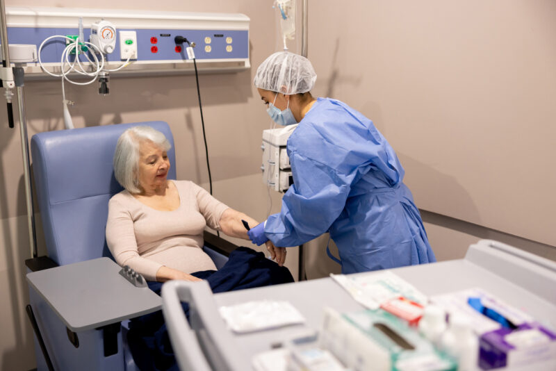 Nurse preparing a senior cancer patient for chemotherapy