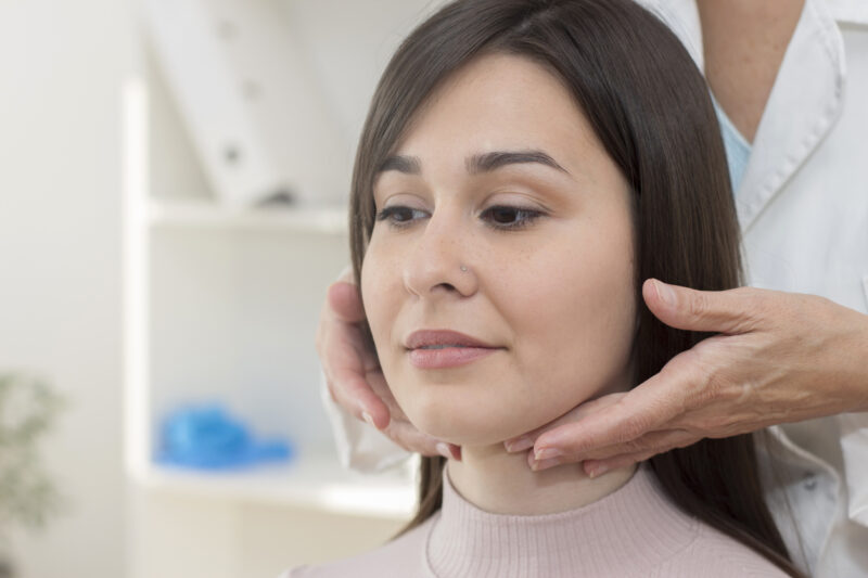 Female doctor examining patient throat