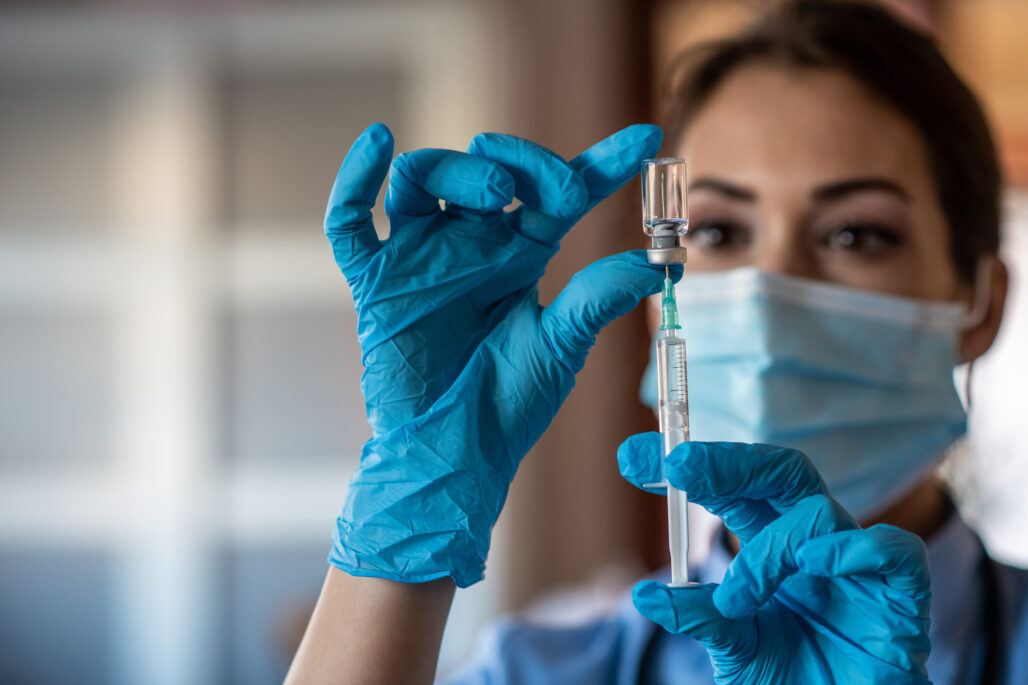 Young care specialist holding syringe