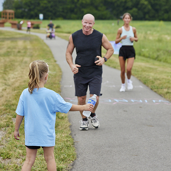 child holding water bottle for runner