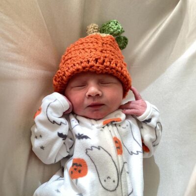 baby wearing Halloween onesie with carrot beanie