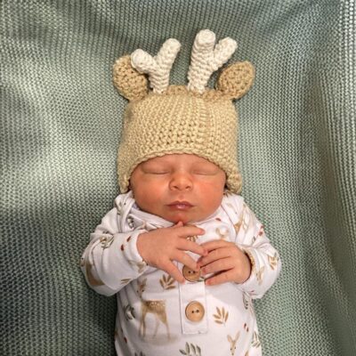 Baby wearing a reindeer antlers beanie