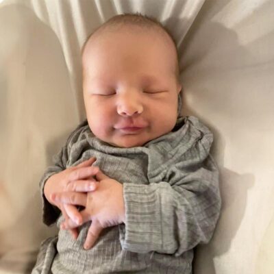 baby wearing grey swaddling clothes