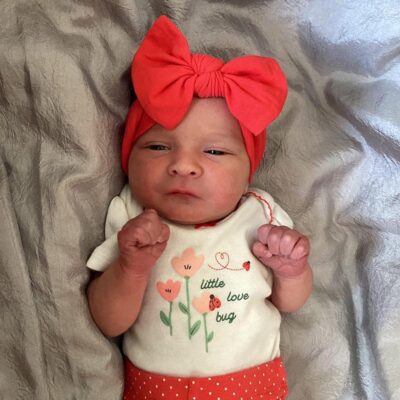 baby wearing orange polka dot outfit